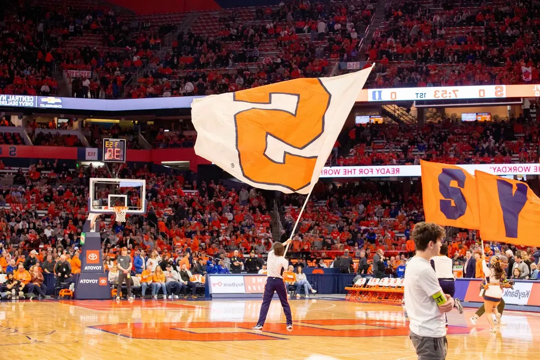 Student waiving a Syracuse University flag in the JMA Wireless Dome.